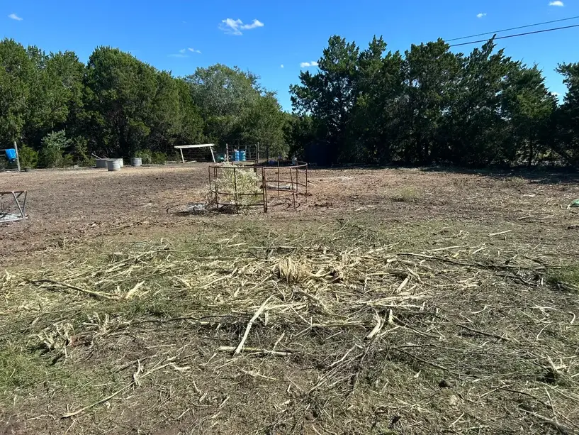 Cut brush and weeds lying on a cleared pasture in Oak Hill, Austin TX