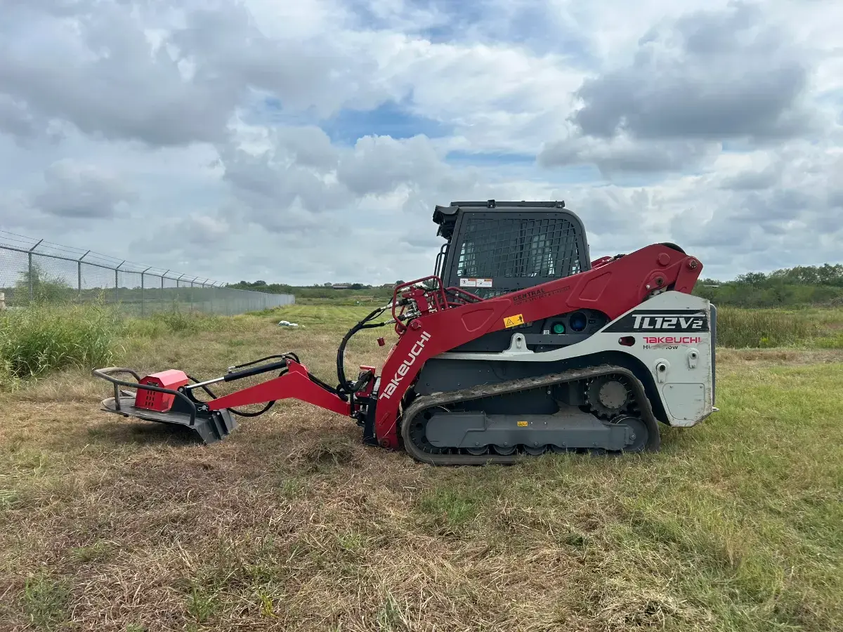 Tracked mulcher cutting grass and brush along pond banks in Martindale TX
